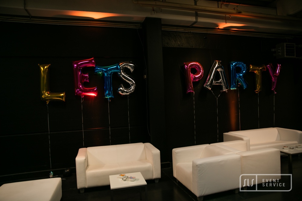 Weiße Loungemöbel vor bunten „LET'S PARTY“-Ballons bei einer Veranstaltung von SLS Eventservice