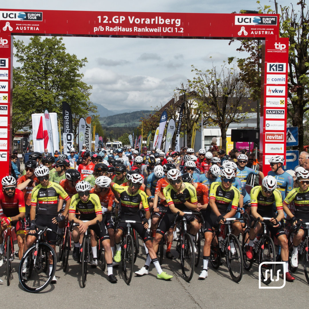 Rennradfahrer stehen dicht gedrängt unter dem Startbogen des 12. GP Vorarlberg in Rankweil