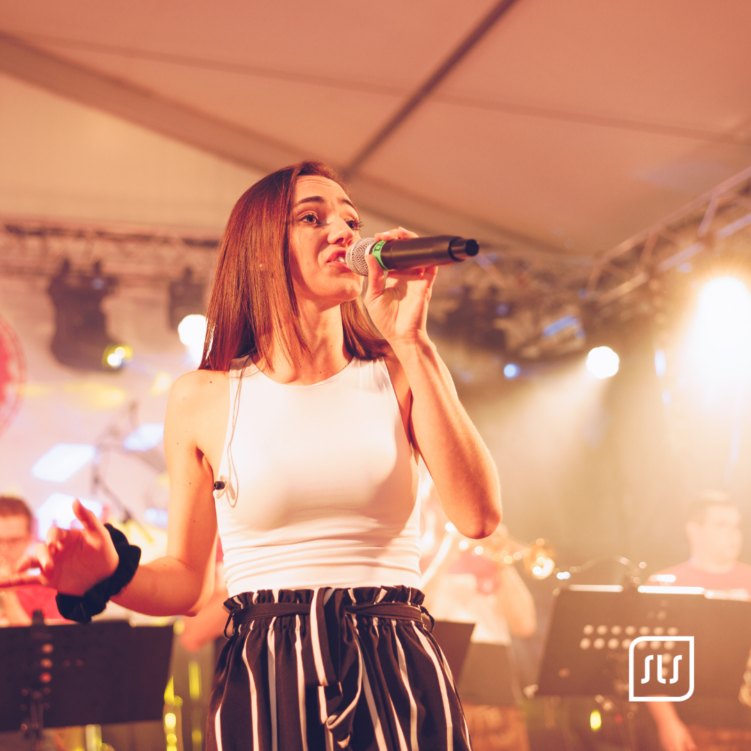 Sängerin der Stutzenmusi singt mit Mikrofon auf der Festzeltbühne beim Schiedlberger Oktoberfest