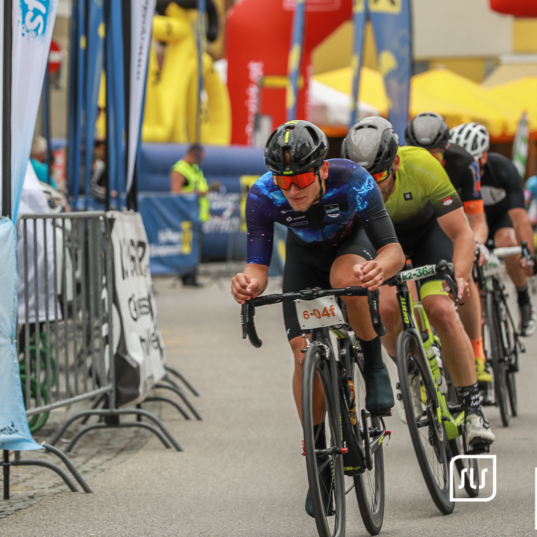 Rennradfahrer in blauschwarzem Trikot führt eine Gruppe beim 24-Stunden-Radmarathon in Grieskirchen an