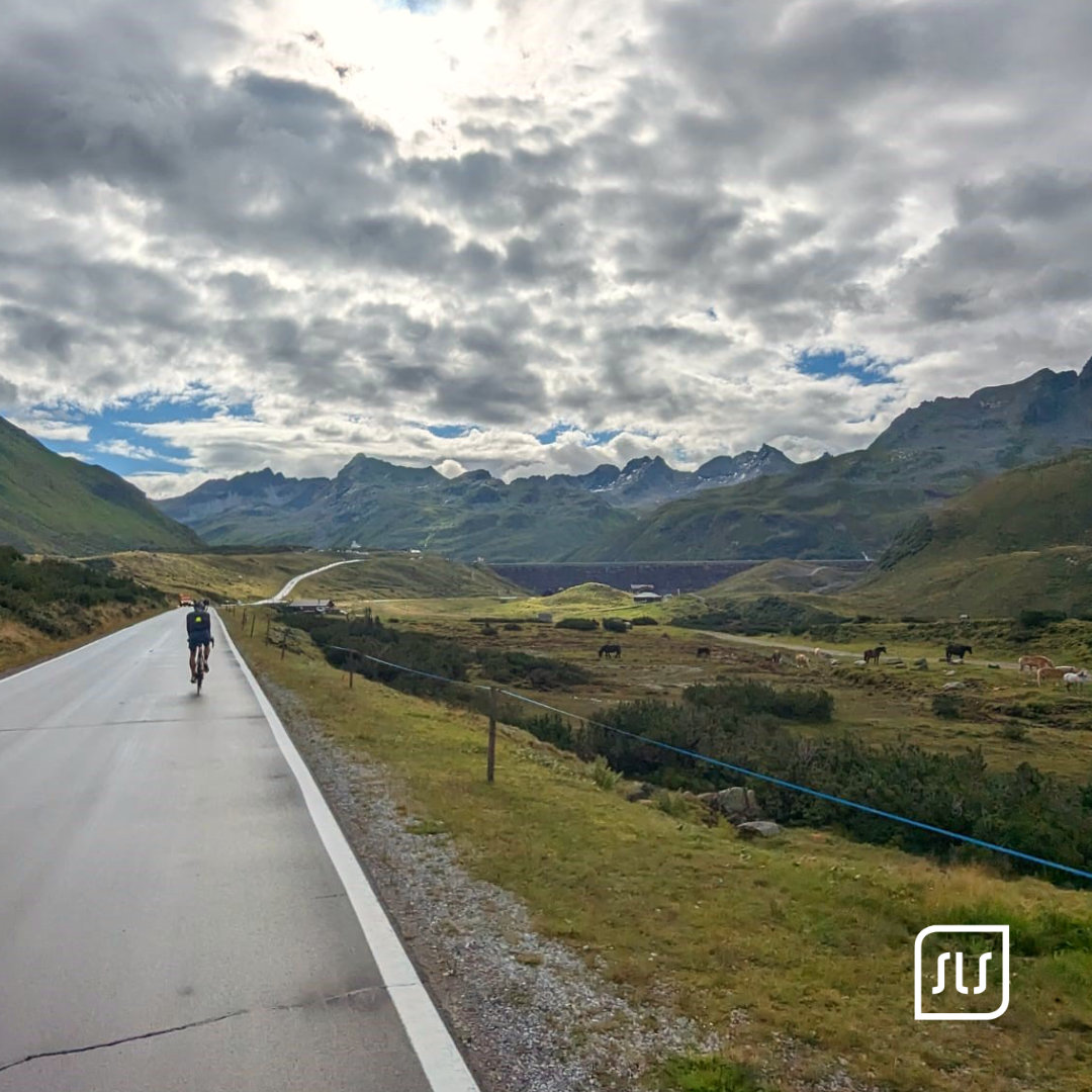 Einzelner Rennradfahrer fährt beim Arlberg Giro 2023 auf einer Bergstraße durch ein weites Tal