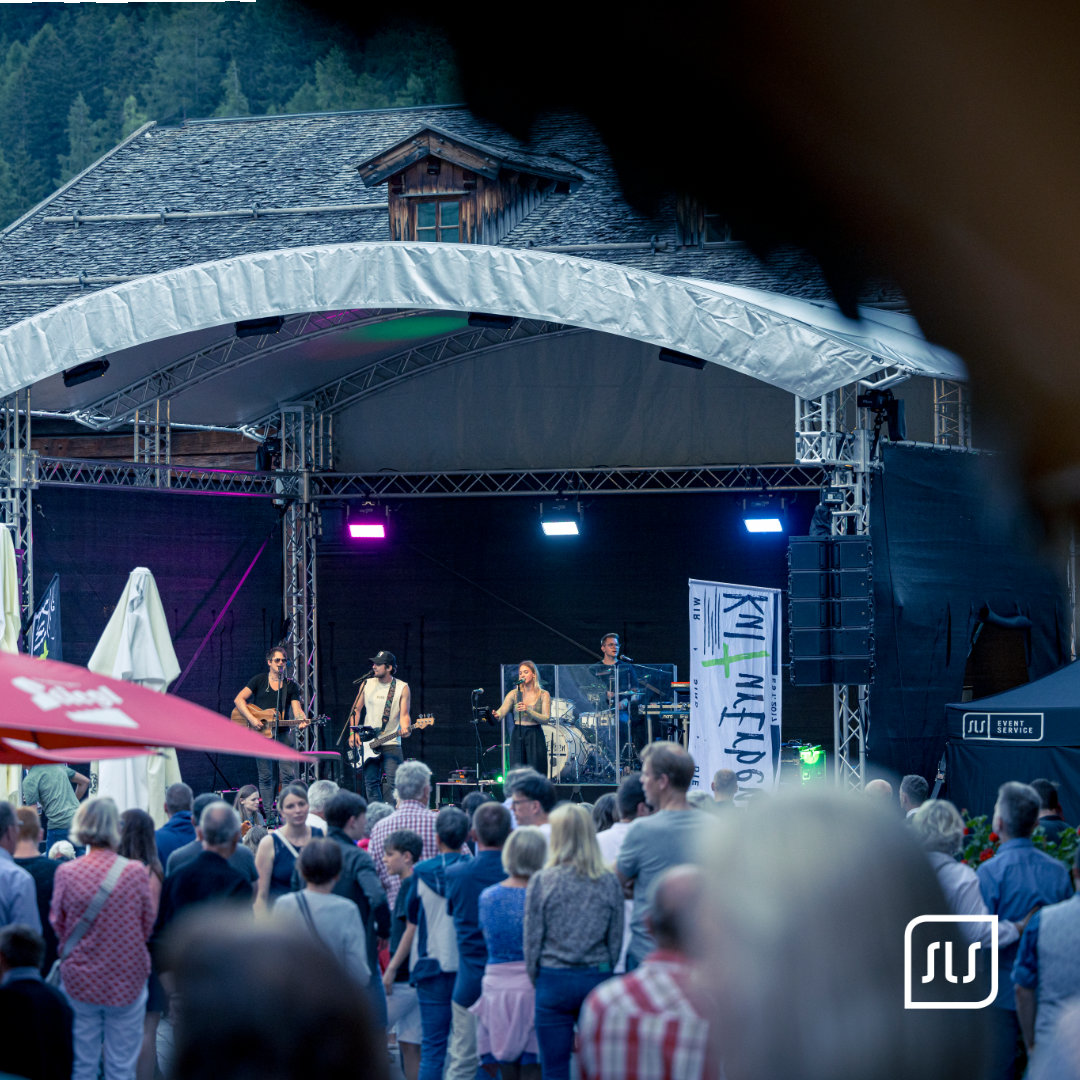 Liveband spielt auf der überdachten Dorffest-Bühne in St. Anton vor dichtem Publikum