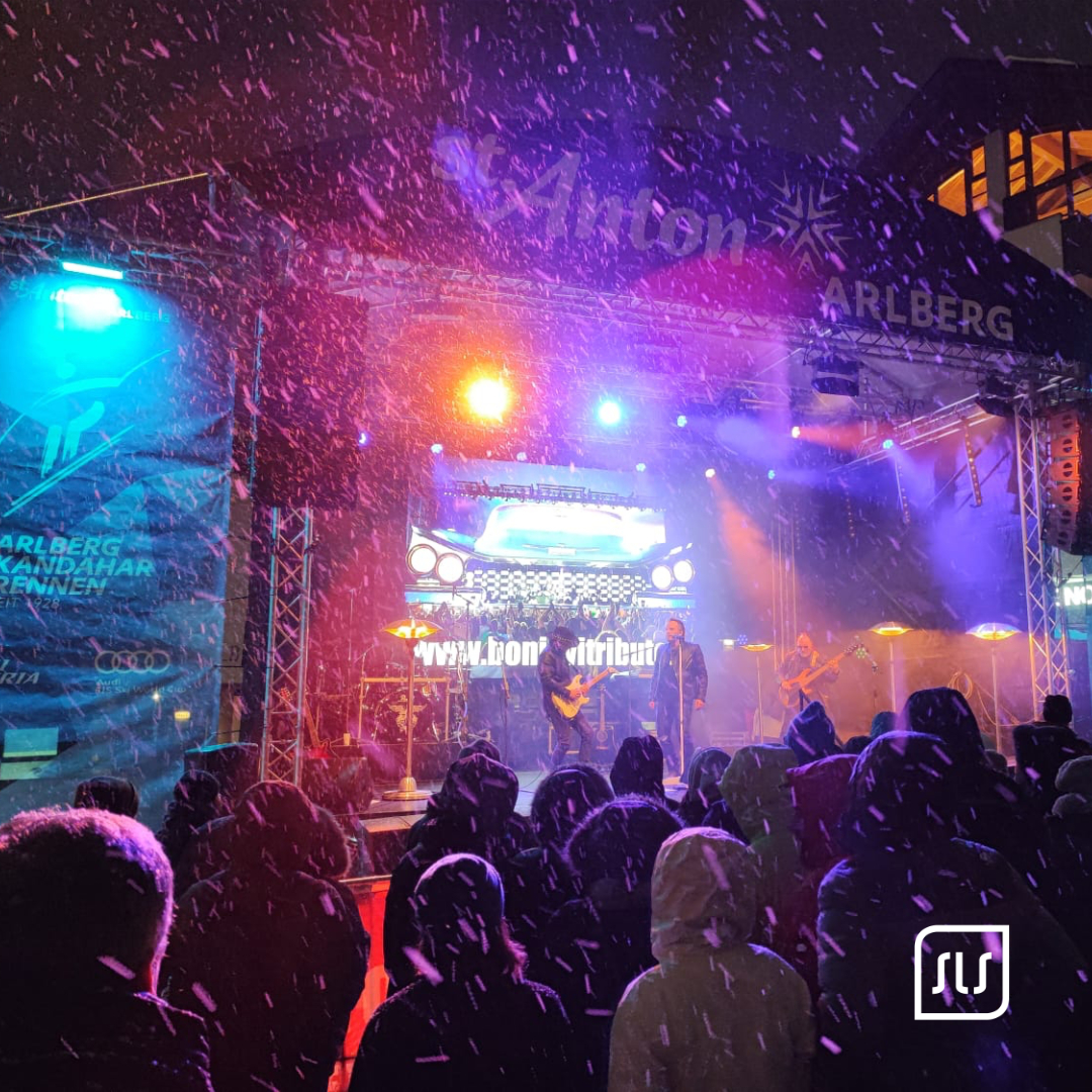 Publikum im Schneetreiben vor bunt beleuchteter Konzertbühne beim FIS Audi Damen-Weltcup in St. Anton