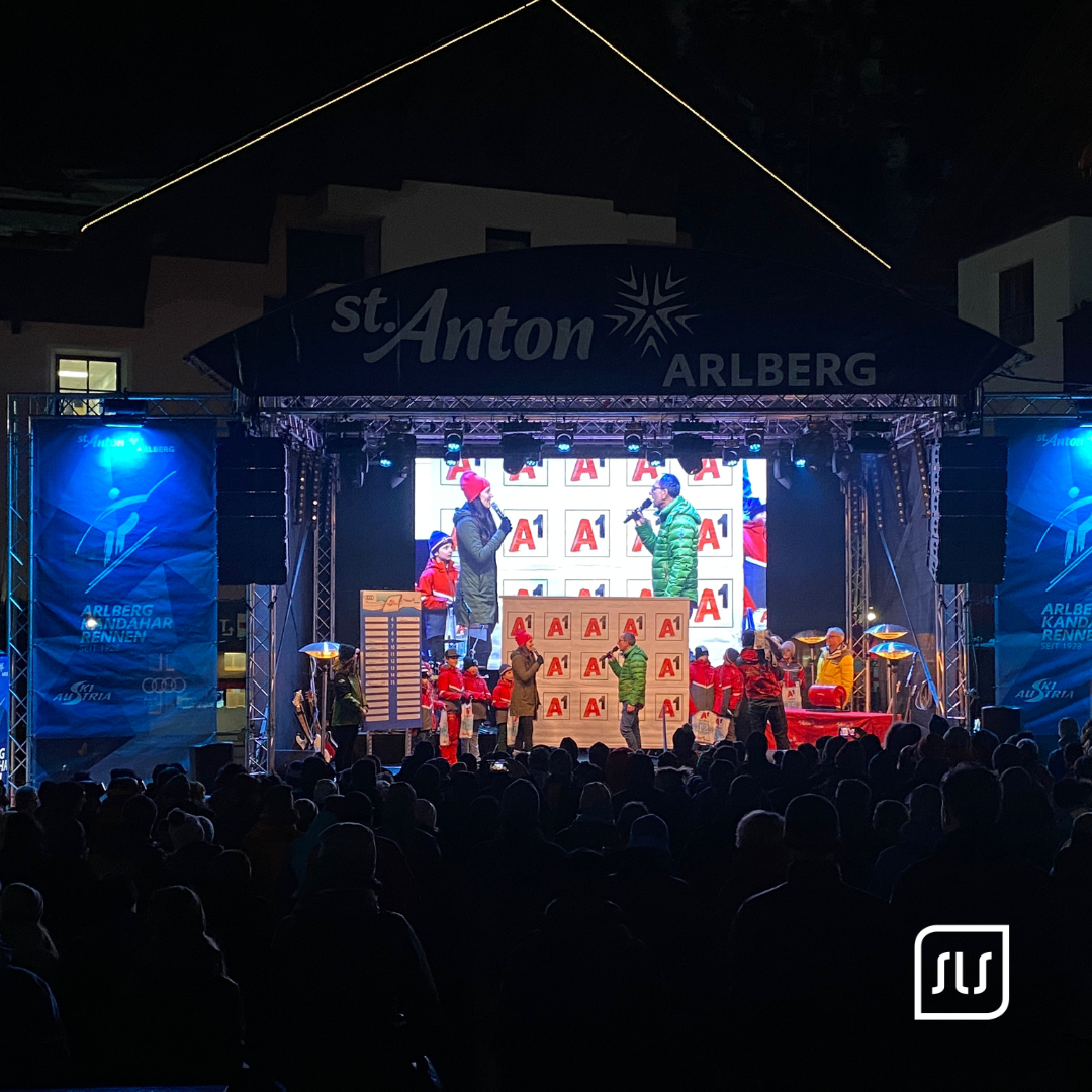 Zwei Personen mit Mikrofonen auf der St.-Anton-Bühne vor Publikum beim FIS Audi Damen-Weltcup