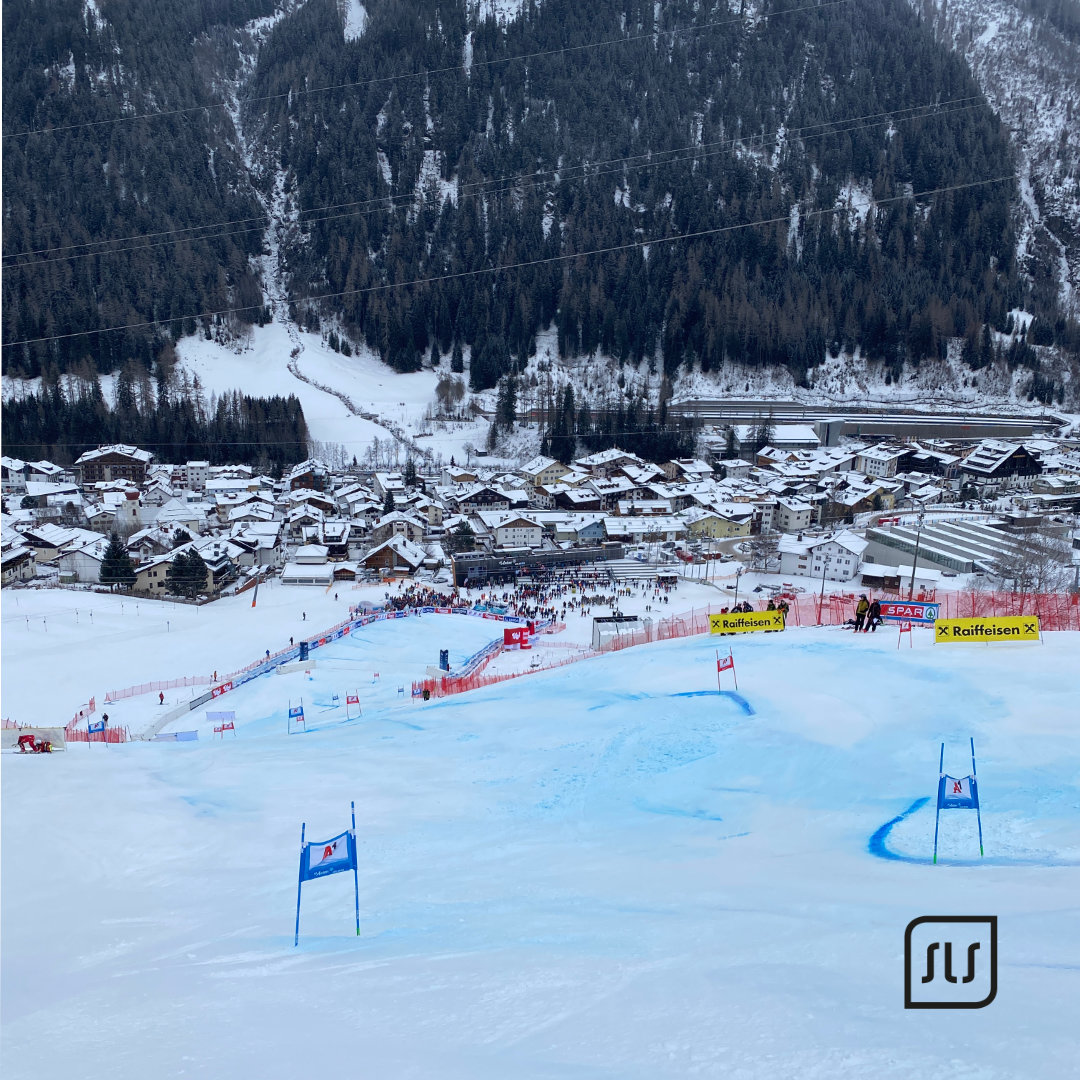 Blick über die mit Toren markierte Weltcup-Skipiste auf das verschneite St. Anton am Arlberg