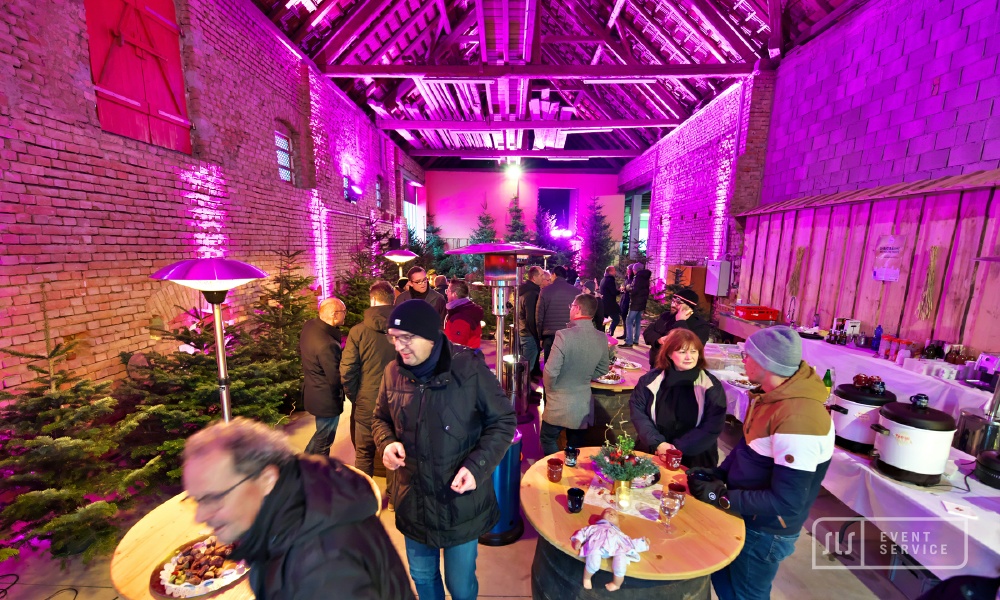 Gäste bei einer stimmungsvoll beleuchteten Winterveranstaltung in rustikaler Eventlocation