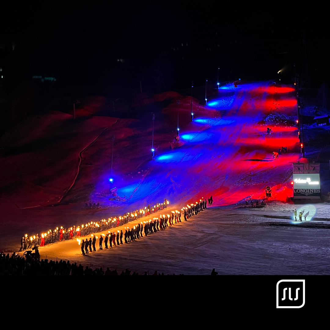 Langer Fackelzug auf einer rot und blau beleuchteten Skipiste bei der JWSC-Eröffnung in St. Anton am Arlberg