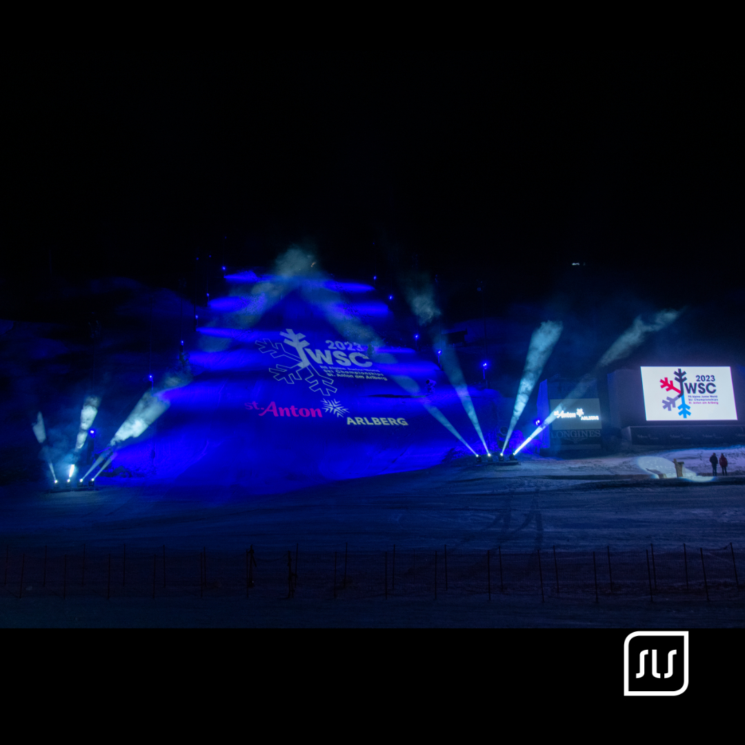 Blau beleuchtete Skipiste mit JWSC-Logo und Lichtstrahlen bei der Eröffnung 2023 in St. Anton am Arlberg