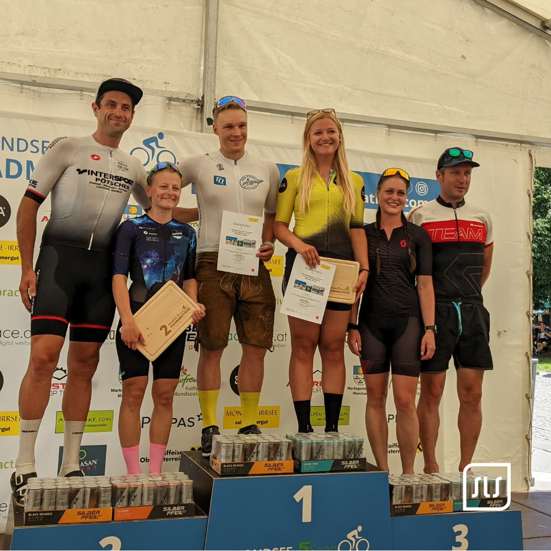 Fünf Radsportlerinnen und Radsportler stehen mit Urkunden auf dem Siegerpodest beim 5-Seen-Radmarathon