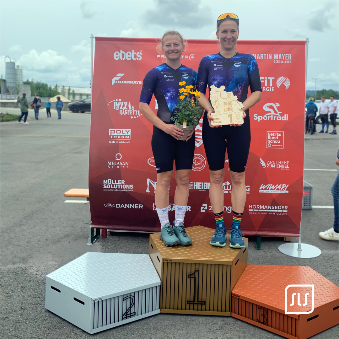 Zwei Radfahrerinnen von SLS Rad Hager stehen mit Blumen und Siegerpreis auf dem Podest bei Bike the Lies