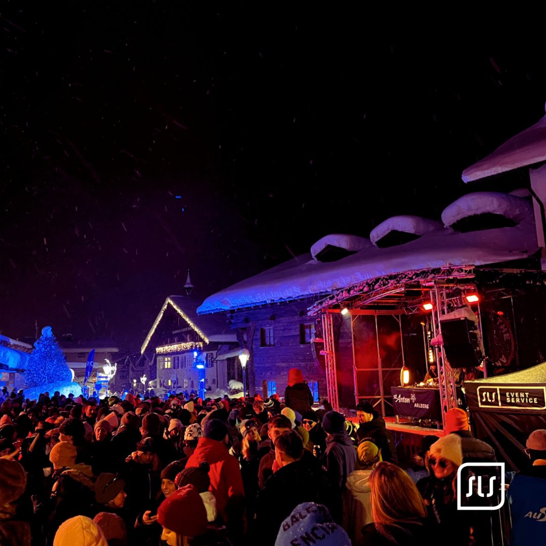 Dichtes Publikum steht nachts vor einer beleuchteten Bühne beim Rave the Arlberg in St. Anton