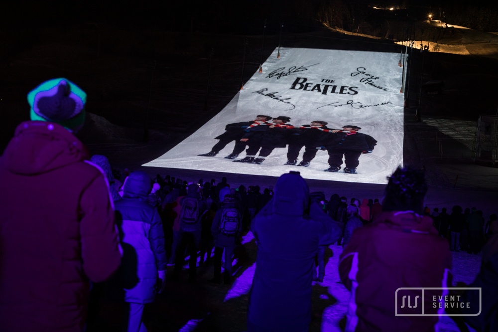 Skishow in St. Anton am Arlberg mit großflächiger Beatles-Projektion auf der Skipiste