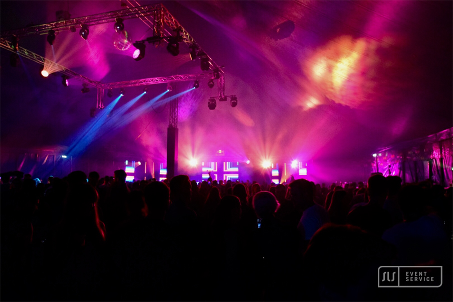 Tanz in der Halle mit großer Menschenmenge und pink-violetter Lichtshow