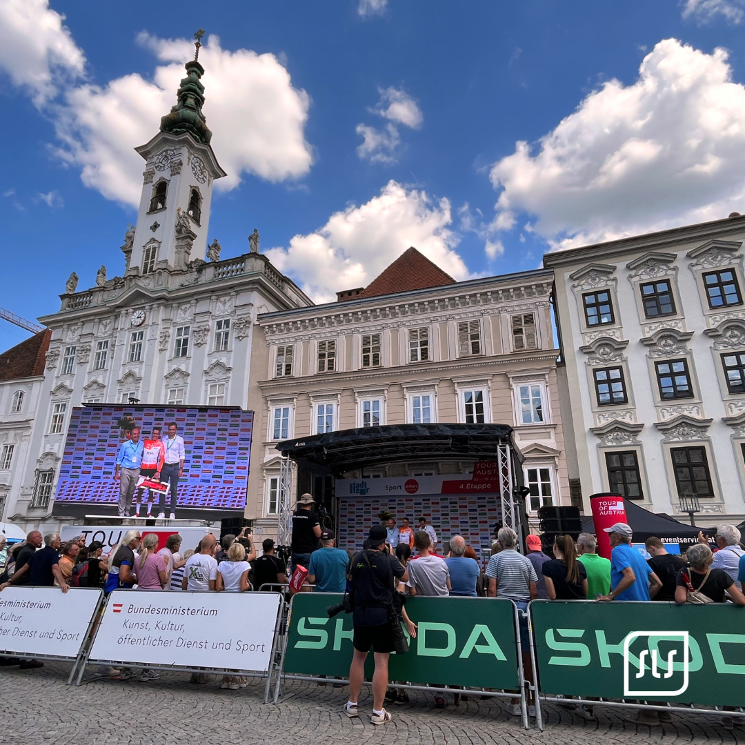 Publikum vor Bühne und großer Videowand bei der Tour of Austria 2023 im historischen Zentrum von Steyr