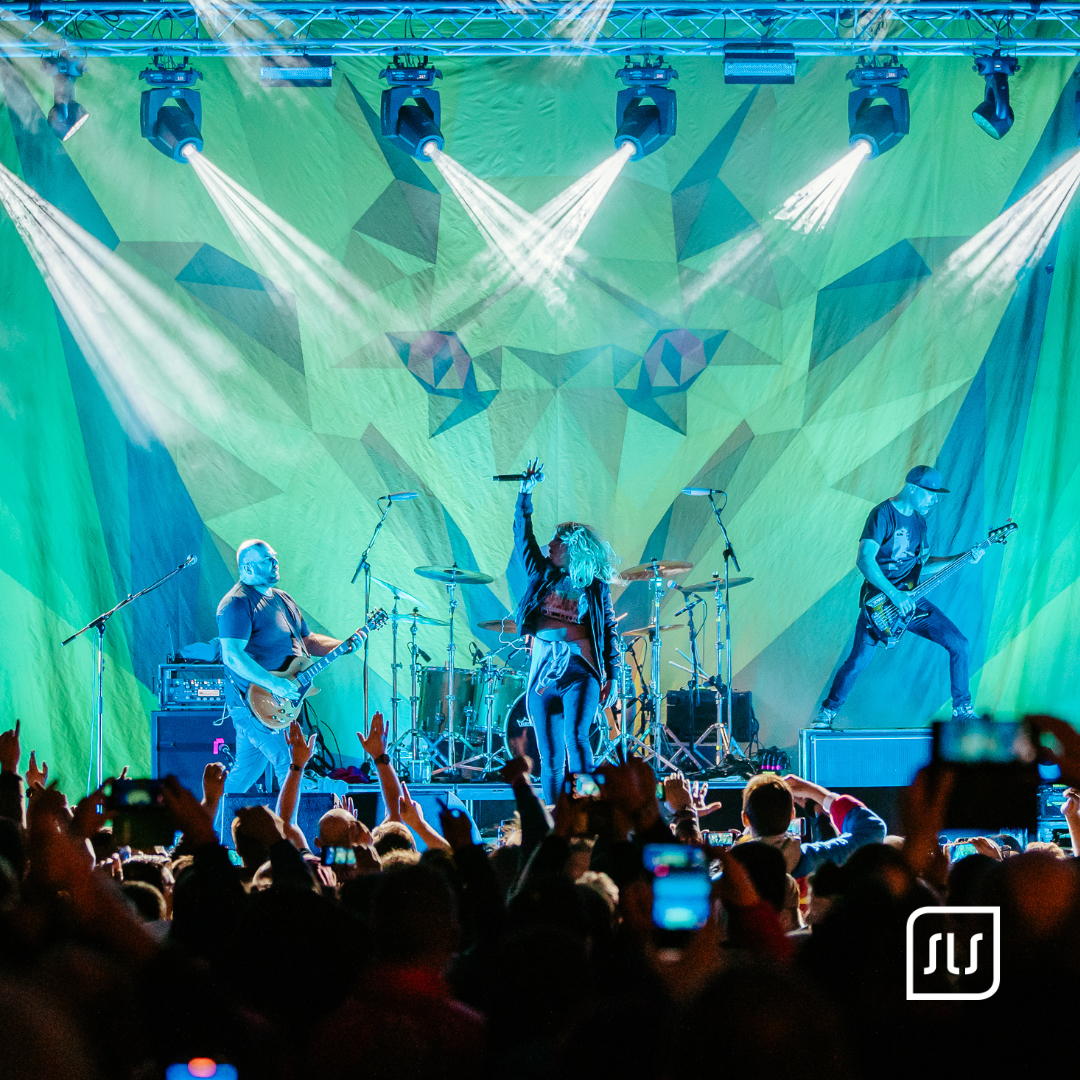Guano Apes spielen auf grün beleuchteter Bühne vor Publikum mit erhobenen Händen beim ZipfAir