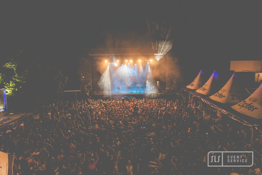 Open-Air-Konzert mit großer Bühne, eindrucksvoller Lichtshow und dichtem Publikum