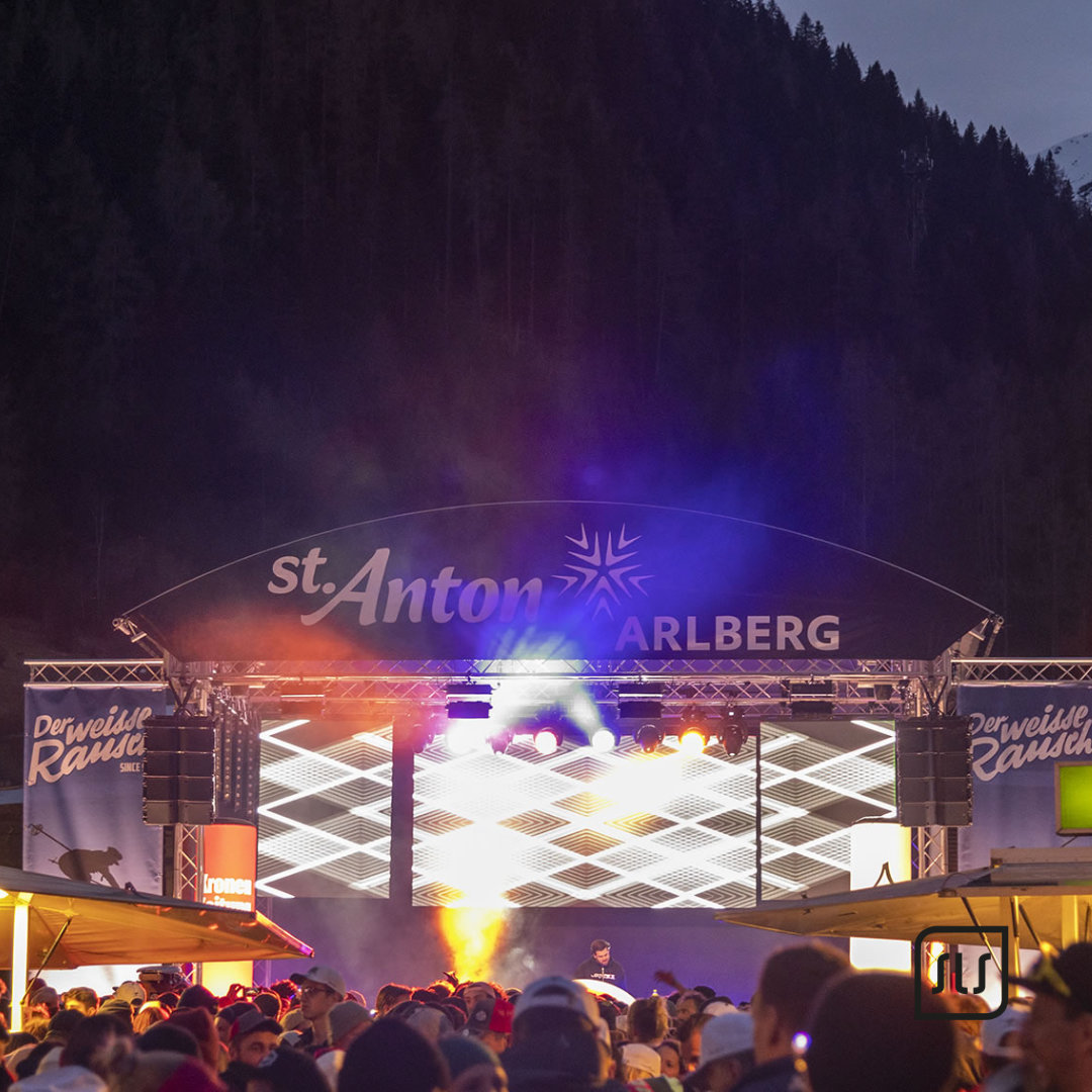 Beleuchtete Bühne mit LED-Flächen und Publikum beim Event „Der weiße Rausch“ 2023 in St. Anton am Arlberg