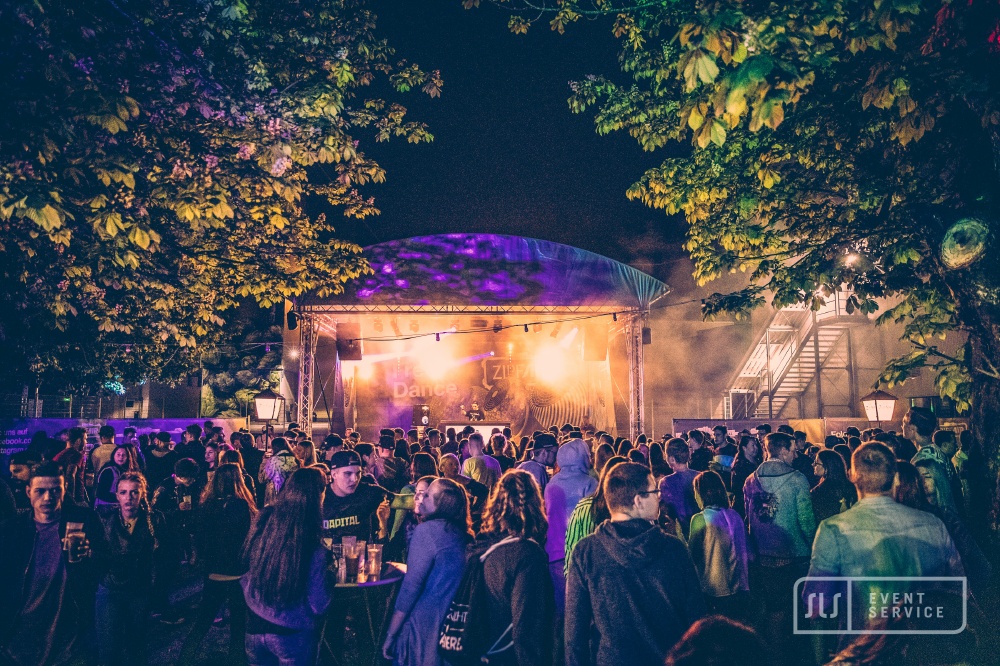Festivalbesucher feiern vor beleuchteter Open-Air-Bühne beim ZipfAir