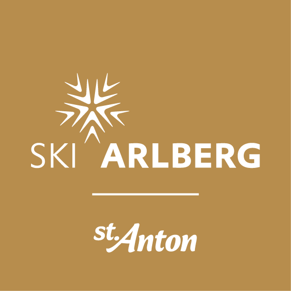 Logo Ski Arlberg St. Anton mit weißer Schneeflocke und Schriftzug auf goldfarbenem Hintergrund
