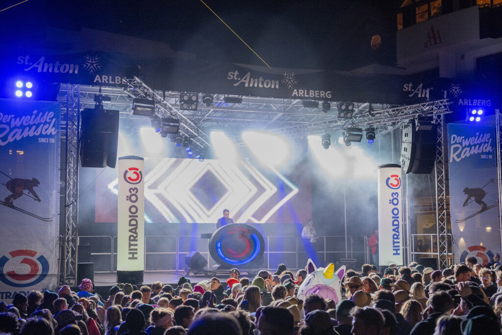 Dichtes Publikum vor einer beleuchteten Bühne mit LED-Grafik beim Weißen Rausch 2026 in St. Anton