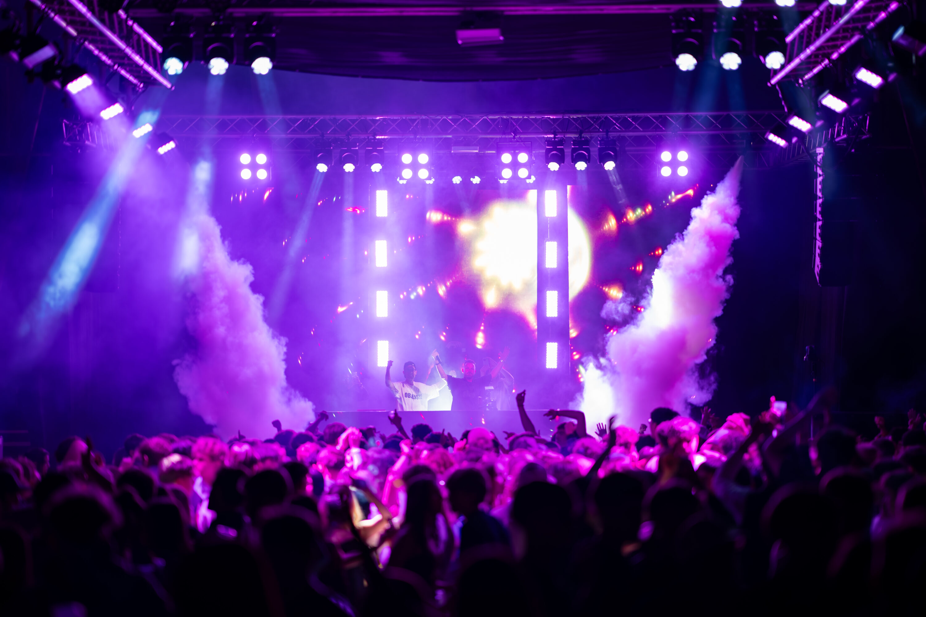 Mainstage bei Tanz in der Halle in Sierning mit violetter Lichtshow, Videowand, Nebeleffekten und Publikum