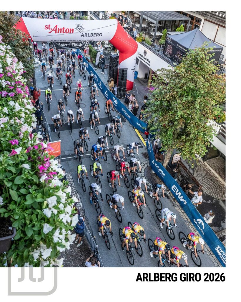 Radfahrer fahren beim Arlberg Giro 2026 unter dem Start-Ziel-Bogen in St. Anton am Arlberg